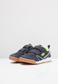 Blaue Sportschuhe mit Klettverschlüssen, neongrünen Akzenten, Gummisohlen und einer strukturierten Oberfläche für Halt und Langlebigkeit.