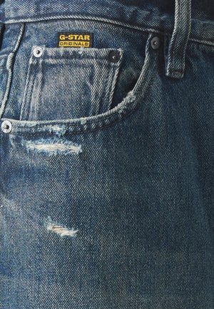 G-Star denim jeans hebben een blauwe kleur met een vervaagd ontwerp, versleten accenten en een zichtbare merklabel op de zak.