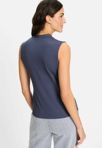 Ärmelloses navyblaues Oberteil aus weichem Stoff, mit Rundhalsausschnitt und lockerer Passform, kombiniert mit gestreiften Hosen. Rückansicht dargestellt.