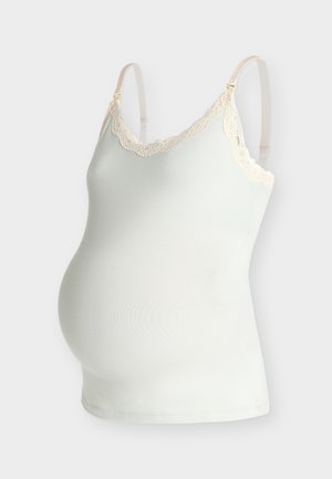 Camisole de maternité blanche avec bretelles réglables et bordure en dentelle crème le long du décolleté sur un fond neutre.