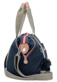 Marineblaue weiche Stofftasche mit hellbraunen Lederdetails, rot-weiß gestreitem Reißverschluss, verstellbarem grauem Schultergurt und einem abnehmbaren schwarzen Plüschanhänger.