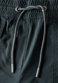 Donkergrijze shorts met een elastische tailleband, metalen oogjes en een gevlochten koord met zilveren uiteinden. Glad, lichtgewicht stof.