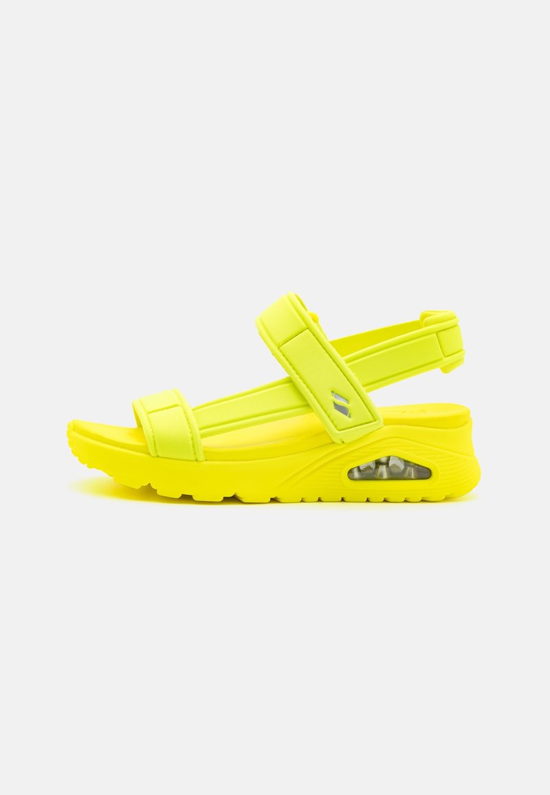 Bright yellow sandals with a cushioned sole, adjustable straps, and a visible air pocket on the side for comfort and support.