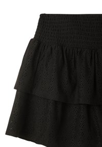 Gonna nera a strati realizzata in tessuto texture con motivo ad occhio di pernice. Presenta una vita arricciata con strati ruffled.