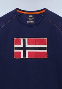 Námořnicky modré tričko s kulatým výstřihem, s oranžovým lemováním na vnitřní straně límce a přišitou norskou vlajkou uprostřed na hrudi.