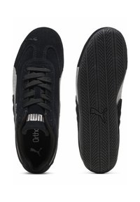 Μαύρο αθλητικό παπούτσι Puma που δείχνει την επάνω όψη με κορδόνια και λογότυπο στο πλάι, καθώς και σόλα με υφή για κράτημα και το εικονίδιο Puma.