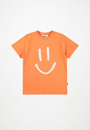 Oranžinė trumpomis rankovėmis marškinėliai su dideliu baltu šypsenėlių piešiniu priekyje, apvalia kaklo iškirpte ir mažu šonu etikete.