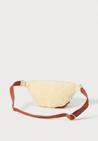 Bauchtasche aus cremefarbenem Kunstfell mit einem taupefarbenen verstellbaren Riemen. Sie hat eine runde Form und eine goldfarbene Hardware-Akzentuierung.