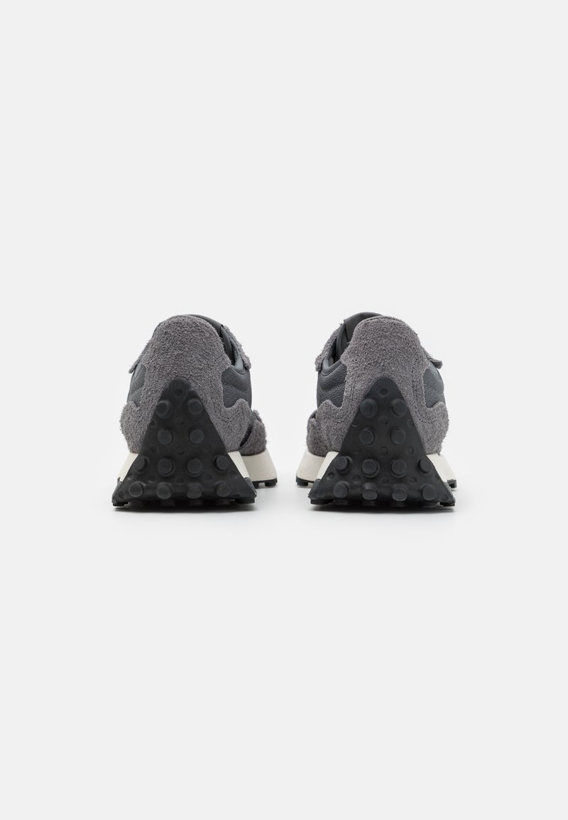 Zapatillas grises con parte superior de ante y malla, un tacón de goma negro triangular y una suela texturizada para mayor tracción.