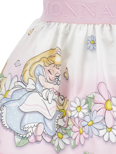 Rosa Stoffrock mit einem Cartoon-Charakter, der eine Blume hält, umgeben von Gänseblümchen und pastellfarbenen Blumen. Elastischer Bund mit "MONNA" Stickerei.
