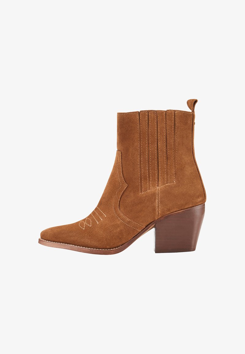 Bottes de cheville en daim marron avec un bout pointu, un talon empilé, des détails de couture verticale et une couture d'accent sur le côté.