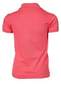 Vaaleanpunainen polo-paita, joka on valmistettu teksturoidusta kankaasta. Ominaisuuksina klassinen kaulus ja lyhyet hihat. Takaviistosta näkyy puhtaat linjat ja istuva muoto.