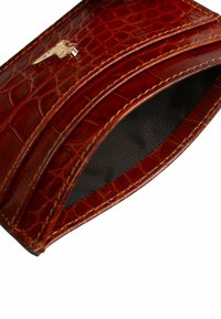 Portafoglio marrone in pelle con motivo a coccodrillo, superficie texture e dettaglio in metallo dorato. Interno foderato in tessuto nero.