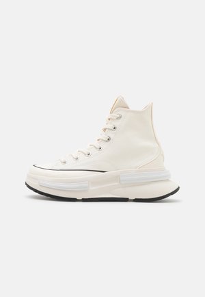 Høje sneakers i off-white lærred med en struktureret finish, sort gummisål og dekorative hvide detaljer på mellemsålen.
