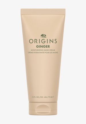 Beige tube med Origins Ginger fuktighetsgivende håndkrem, med grønn tekst, flip-top kork og preget trelogo. Inneholder 75 ml.