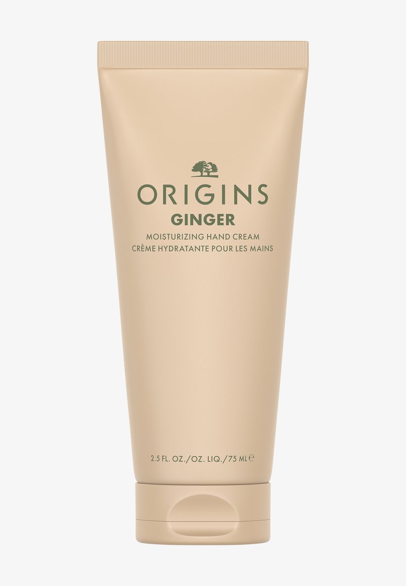 Beige Origins Ginger -kosteuttavan käsivoiteen tuubi, jossa vihreä teksti, kääntyvä kansi ja kohokuvioitu puun logo. Tilavuus 75 ml.