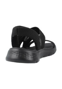 Sandalias negras con una parte superior de tejido texturizado, correas cruzadas y una suela acolchada. Presentan una suela exterior duradera y flexible para mayor comodidad.