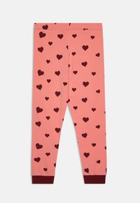 Roze katoenlegging met een verspreid patroon van donkerrode harten, voorzien van een effen donkerrode zoom en een elastische tailleband.