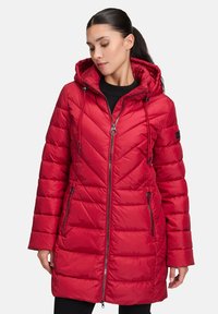 Rote gepolsterte Jacke mit Kapuze, ausgestattet mit einem Zickzackmuster, Reißverschluss und zwei seitlichen Reißverschlusstaschen. Glatte Textur mit verstellbaren Kordeln.