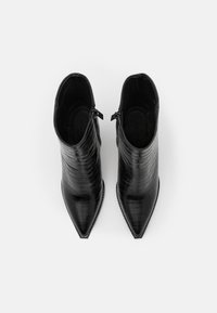 Bottines noires à bout pointu, fabriquées en cuir de crocodile synthétique, avec des fermetures éclair sur les côtés et une texture lisse.
