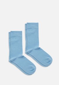 Lyseblå bomuldsokker med en glat tekstur, der har et enkelt design og ribbede manchetter øverst. Rund tå og lav hæl.