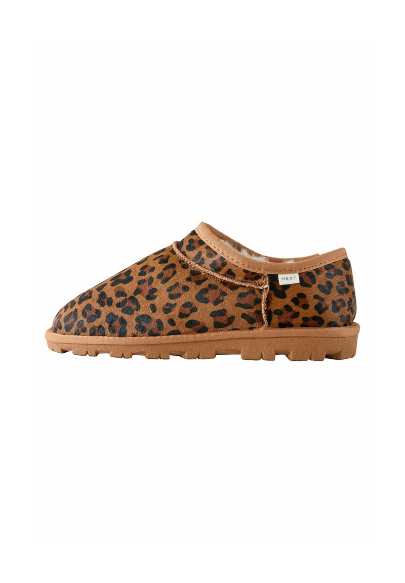 Zapatillas de slip-on con estampado de leopardo, upper de piel sintética en tono tostado, puntera redondeada y suela de goma texturizada. Presenta un detalle decorativo de costura.