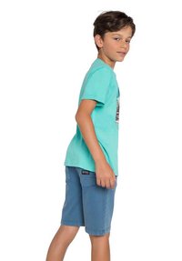 Turkooise katoenen T-shirt met korte mouwen, voorzien van een grafische print. Gecombineerd met lichtblauwe shorts met een zakdetail.