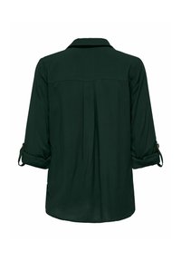Chemise à manches longues vert foncé avec manches retroussées maintenues par des pattes à boutons, empiècement dos visible et détail de pli central.