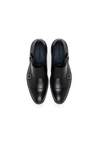 Czarne skórzane buty o eleganckim wzornictwie, z podwójnym zapięciem na klamry, gładką teksturą i dekoracyjnym przeszyciem wzdłuż cholewki.