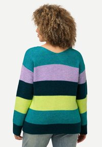 Sweter w paski w kolorach zielono-niebieskim, zielonym, fioletowym i żółtym. Posiada dekolt w serek i długie rękawy, z teksturowanym wykończeniem dzianiny. Luźny fason.