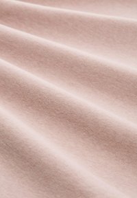 Miękka, jasnoróżowa tkanina o gładkiej, delikatnej fakturze oraz łagodnych fałdach tworzących skośne cienie i rozświetlenia na powierzchni.