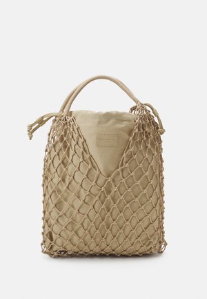 Bolsa de tela beige con exterior de malla y asa corta envuelta, con un pequeño parche rectangular de la marca en el centro frontal.