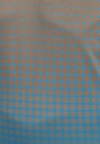 Textil mit einer strukturierten Oberfläche, das ein Muster aus braunen Kreisen und blauen Rauten auf einem Farbverlaufshintergrund zeigt, das visuelles Interesse weckt.