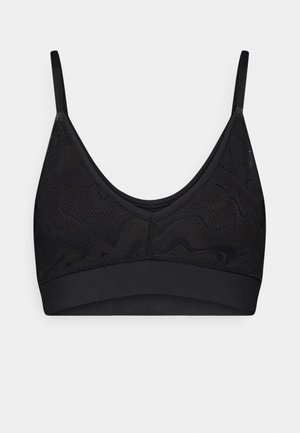 Svart trådløs bralette med en glatt underbånd, med et teksturert mesh-overlegg med et bølgete mønster og justerbare tynne stropper.