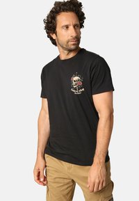 Zwarte katoenen T-shirt met een schedel- en rozenontwerp op de borst, korte mouwen en een klassieke pasvorm. Gladde textuur, casual ontwerp.