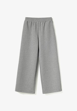 Pilkos plačios kelnės, pagamintos iš minkštos, elastingos medžiagos. Turi elastingą juosmenį ir lygų paviršių be matomų raštų ar akcentų.