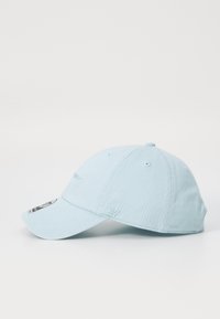 Căciulă din bumbac bleu deschis, cu o margine curbă, logo brodat în față și orificii de ventilație pe laterale. Accentuata cu un etichetă.