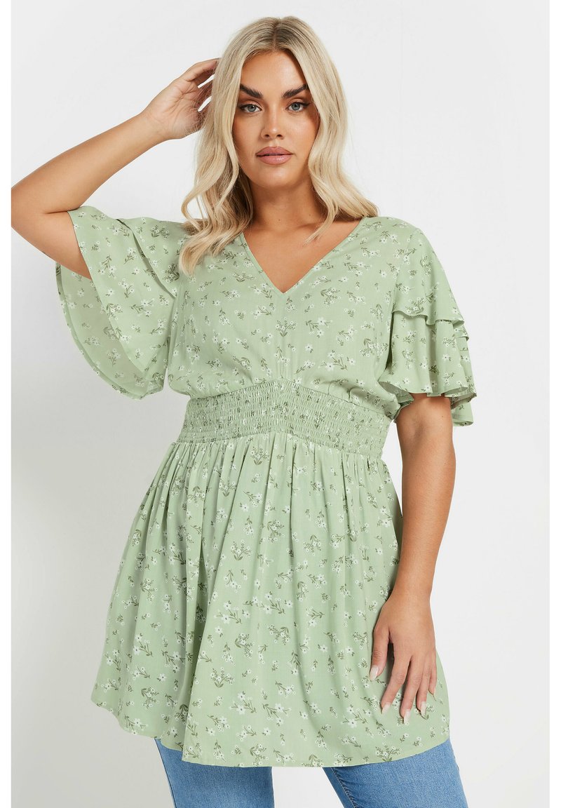 Light green floral top with a V-neck, short ruffled sleeves, and a smocked waist. Flowy design with small white and yellow flower patterns.