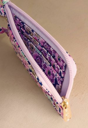 Lille stofpose med lilla blomsterprint, lyserød lynlås og guldfarvet lynlåstrækker, delvist åben for at vise det indvendige stoffor.