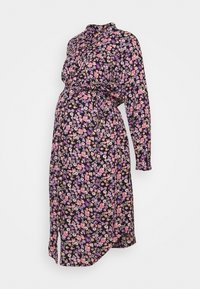 Černé květinové šaty s dlouhými rukávy, zdobené malými fialovými a růžovými květy, s vypasovaným pasem a bočním rozparkem pro snadný pohyb.