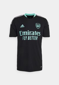 Czarny trykot piłkarski z turkusowymi akcentami. Cechy to krótkie rękawy, okrągły dekolt oraz wyraźne logo "Emirates Fly Better".