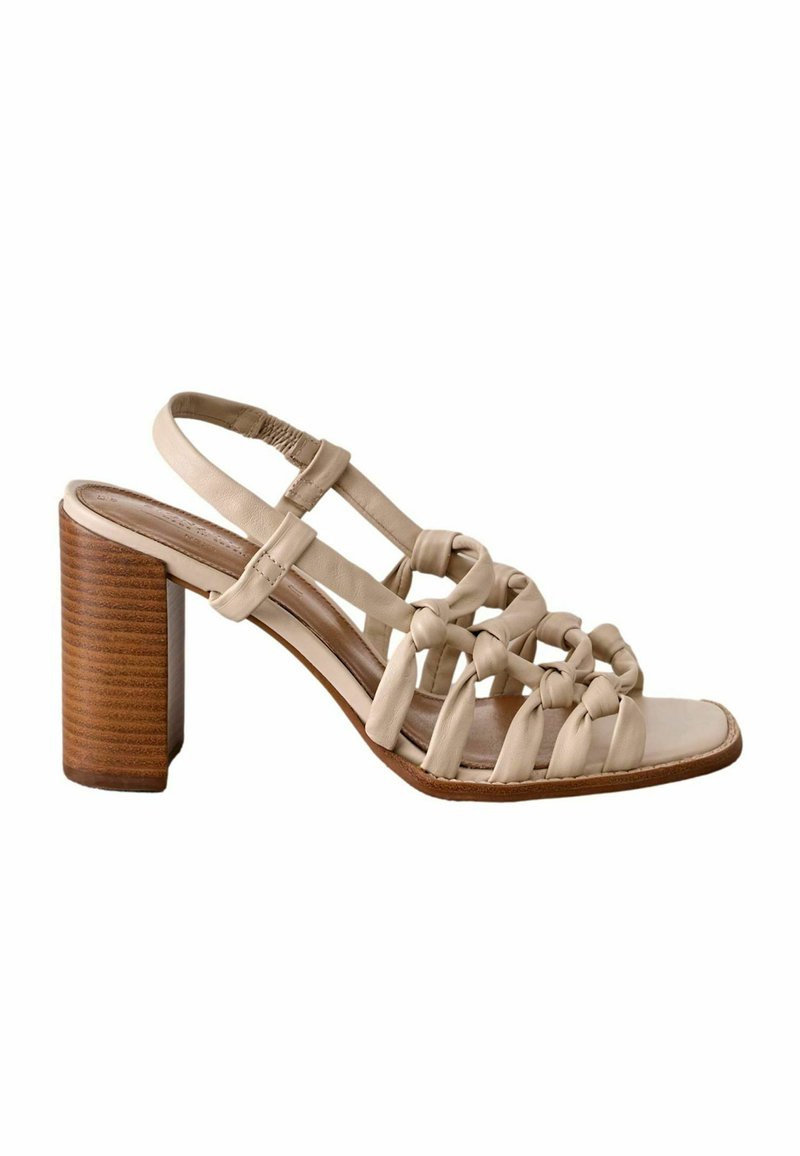 Sandale à talon beige avec des brides en cuir nouées, ouvertes sur le devant et un talon en bois. Texture lisse avec un design minimaliste.