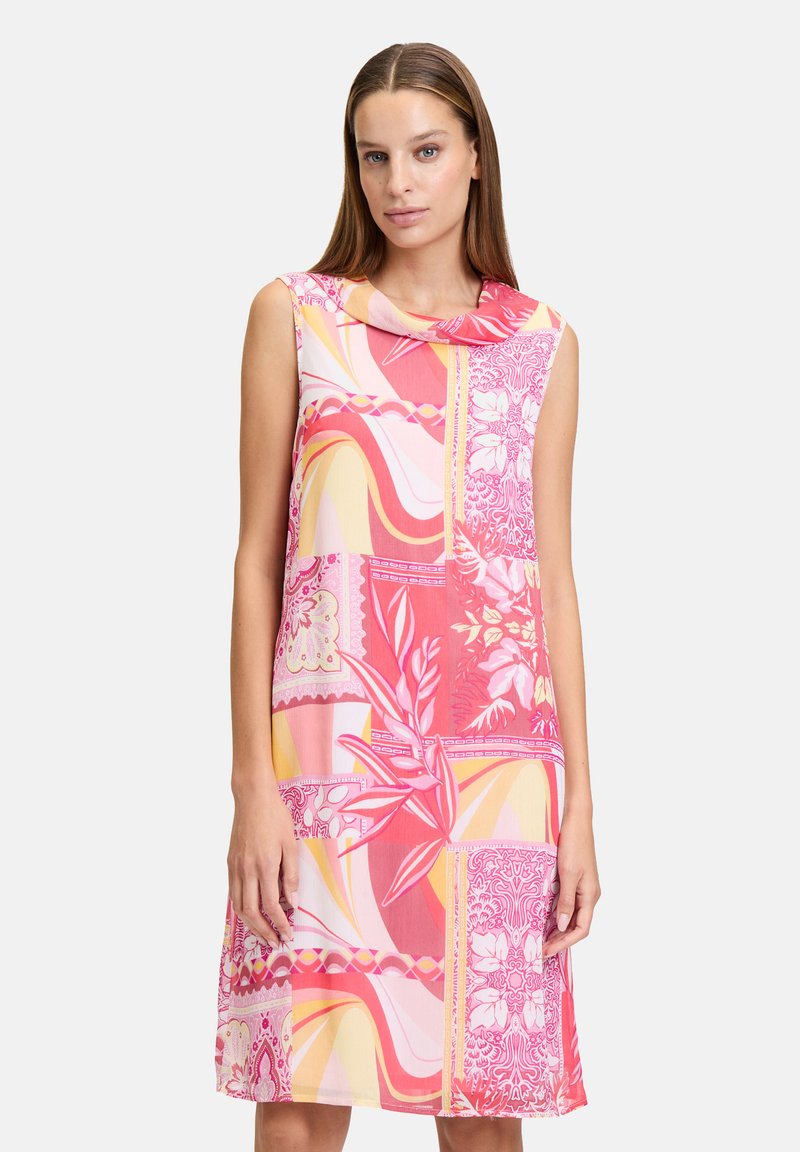 Robe sans manches avec des motifs roses et jaunes, comportant des designs floraux et abstraits. Tissu doux, coupe décontractée, silhouette longueur genou.