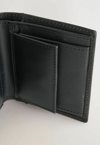 Schwarze Lederbörse mit glatten und strukturierten Abschnitten, mehreren Kartenfächern und präziser Naht entlang der Kanten.