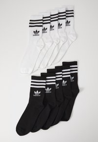 Lot de 6 chaussettes : 3 blanches avec des rayures noires et logo, 3 noires avec des rayures blanches et logo. Mélange de coton, longueur mi-mollet, design athlétique.