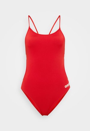 Bañador rojo de una pieza con finas doble tirantes en los hombros y pequeño logo blanco "arena" cerca de la cadera derecha, mostrado sobre un fondo claro y liso.