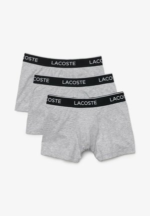 Boxer-briefs en coton gris, avec une ceinture élastique noire portant le logo "LACOSTE" en blanc. Trois paires empilées, texture lisse.