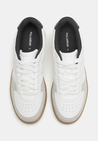 Weiße Sneakers mit einem glatten Lederoberteil, grauen Wildlederakzenten, runder Zehenform und Gummilaufsohle. Mit Schnürverschluss und gepolstertem Kragen.