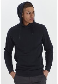 Sudadera con capucha en azul marino hecha de tela suave, cuenta con un bolsillo frontal y cordones ajustables en la capucha, puños ajustados.