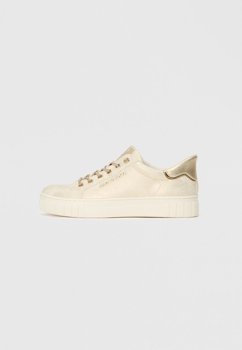 Μπεζ σουέτ αθλητικά παπούτσια με μεταλλικές χρυσές λεπτομέρειες, χαρακτηριστικά επενδεδυμένος λαιμός, κούμπωμα με κορδόνια και καουτσούκ σόλα με υφή.